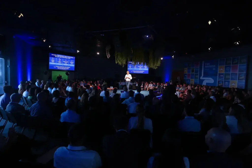 Como alinhar cultura e propósito em eventos corporativos Apresentação em evento corporativo com público sentado em formato circular